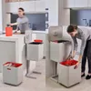 A kitchen scene showing a person using a recycling bin. Podgląd zdjęcia produktu