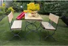 A picnic table and benches set up in a garden with a red slide in the background. Náhled obrázku produktu