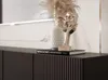 A close-up view of a modern TV lowboard with decorative items on top. Voir les images du produit