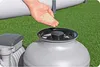 A hand is pouring sand into a pool filter. Produktbild-Vorschau