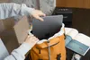 A person is placing a laptop into an orange backpack. There is a speaker and a magazine on the table. Náhled obrázku produktu