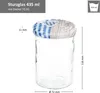 A clear studio shot of a glass jar with a patterned lid, featuring measurement indicators. Voir les images du produit
