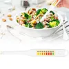 A hand holding a food salt tester over a bowl of salad. Náhled obrázku produktu
