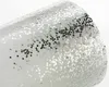 A close-up of a white surface covered in silver and black glitter. Produktbild-Vorschau