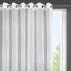 A white sheer curtain with grommets hangs in front of a window. Voir les images du produit