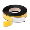 A roll of black magnetic tape with yellow adhesive backing, partially unrolled, against a white background. Podgląd zdjęcia produktu