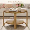 A two-tier round coffee table made of wood, placed in a living room setting with a sofa and pillows in the background. Produktbild-Vorschau