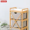 A bamboo laundry sorter with three fabric bins against a light gray wall. Anteprima dell’immagine prodotto