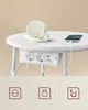 A white round table with integrated power outlets and USB ports, featuring a spilled cup of coffee and a charging phone. Náhled obrázku produktu