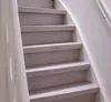 A close-up view of a light gray concrete staircase with white railings. Voir les images du produit