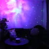 A living room with a projector displaying a galaxy and stars on the wall, with a sofa and coffee table in the foreground. Podgląd zdjęcia produktu