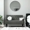 A dark gray tufted bench with a round white pillow and a white throw blanket draped over it, placed in a bedroom setting. Produktbild-Vorschau