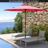 A red patio umbrella shades two lounge chairs next to a pool with a stone wall in the background. Produktbild-Vorschau