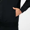 A close-up shot of a person's hand in the pocket of a black jacket. Produktbild-Vorschau