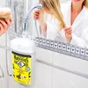 Lifestyle-Präsentation der Le Petit Marseillais Duschcreme „Lait de Vanille BIO“ – Die Flasche mit Bio-Vanillemilch ist in einem hellen Badezimmer vor einem Spiegel platziert, in dem sich eine Frau im weißen Bademantel bei der Haarpflege spiegelt. Produktbild-Vorschau