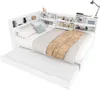 A white daybed with a pull-out trundle bed, featuring a headboard with integrated storage compartments and shelves. The bed is made with white bedding and a brown throw blanket. Produktbild-Vorschau