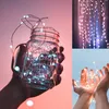 A collage of three images showing string lights. The top left shows string lights inside a mason jar held by a hand. The top right shows string lights hanging vertically. The bottom right shows string lights in cupped hands. Voir les images du produit