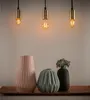 Three pendant lights hang above a wooden tray holding three decorative vases. Produktbild-Vorschau