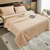 A cozy bedroom scene with a plush blanket draped over a bed. Produktbild-Vorschau
