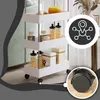 A white rolling storage cart with various items on its shelves, including jars of food, and a close-up of a wheel with a 360-degree rotation indicator. Podgląd zdjęcia produktu