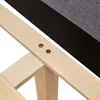 A close-up view of the wooden frame and fabric upholstery of a bed. Voir les images du produit