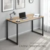 A modern office desk with a laptop, cup of coffee, and a notebook is set up in a well-lit room with artwork on the wall and curtains in the background. Produktbild-Vorschau