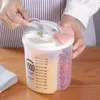 A person's hands are shown opening the lid of a multi-compartment food storage container filled with grains and nuts. Produktbild-Vorschau