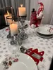 A Christmas-themed table setting with candles, plates, and cutlery holders. Podgląd zdjęcia produktu