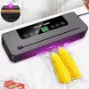 A vacuum sealer machine is shown sealing bags of corn and meat. Náhľad obrázku produktu