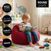A young boy is reading a book while sitting on a red beanbag chair in a child's room. Voir les images du produit