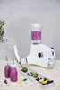 A white blender with a pitcher filled with purple liquid, two bottles of purple smoothie, and a tray of berries and lemon slices on a wooden surface. Anteprima dell’immagine prodotto