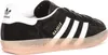 A side view of a black Adidas Gazelle sneaker with white stripes and a translucent pink sole. Produktbild-Vorschau