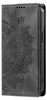 A close-up, side view of a black flip phone case with a mandala design embossed on the cover. Produktbild-Vorschau
