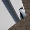 A close-up view of a wheel on a white cooler box, resting on a paved surface. Produktbild-Vorschau