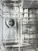 Close-up view of the interior of a dishwasher, showing the spray arm and racks. Produktbild-Vorschau