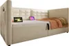 A beige upholstered sofa bed with a tufted headboard, shown with two tablets and a blanket. Produktbild-Vorschau