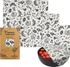 A set of beeswax food wraps with a vegetable pattern, displayed with packaging and a bowl of tomatoes. Náhľad obrázku produktu