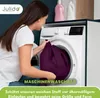 A woman is putting a purple fabric into a washing machine. Produktbild-Vorschau