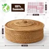 A woven basket with a lid and a folded kitchen towel with red stripes. Anteprima dell’immagine prodotto