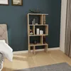 A modern wooden bookshelf filled with decorative items, placed in a bedroom next to a bed. Produktbild-Vorschau
