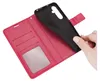 A hand is holding a black phone case over a red wallet-style phone case. Produktbild-Vorschau