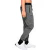 A person wearing grey Under Armour joggers and white sneakers, shown from the side. Produktbild-Vorschau