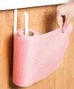 A hand is pulling a paper towel from a roll holder mounted under a cabinet. Podgląd zdjęcia produktu
