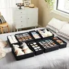 Closet organizers filled with underwear and bras are arranged on a bed next to a dresser. Produktbild-Vorschau