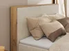 A close-up view of a bed with pillows and a wooden headboard. Produktbild-Vorschau