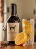 A bottle of Windspiel Premium Dry Gin is displayed next to a glass of gin and tonic, an orange slice, and peppercorns. Produktbild-Vorschau