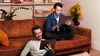 Two men are sitting on the floor and on a couch, each using a tablet. Náhled obrázku produktu