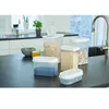 A collection of clear plastic food storage containers with white lids on a dark countertop. Produktbild-Vorschau