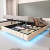A bed with its storage compartment open, revealing folded linens and blankets, with blue LED lighting underneath. Náhľad obrázku produktu