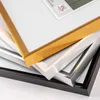 A close-up view of stacked picture frames in different colors and finishes. Produktbild-Vorschau